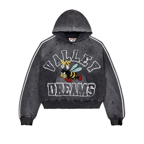 Vale Forever Anthem distressed black hoodie with white sleeve stripes. Front: "VALLEY", angry bee attacking "VS" logo, "DREAMS".