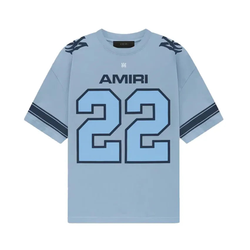 AMIRI Skater Tee, sky blue, with dark blue "AMIRI" text, logo, "22" number, shoulder patterns, & sleeve stripes.