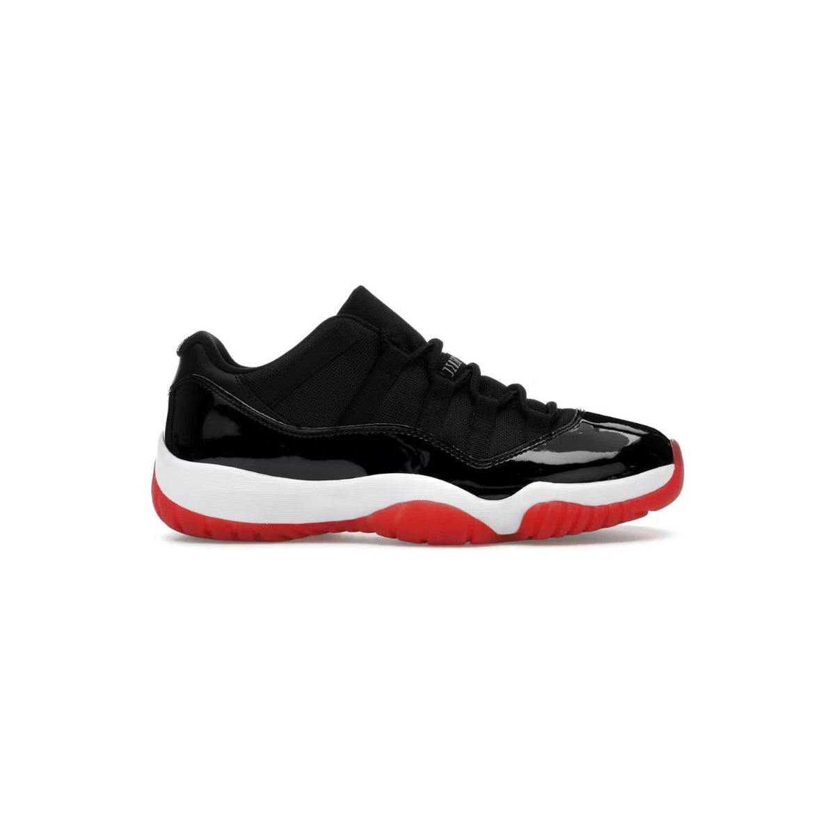 Air Jordan 11 Retro Low Bred sneaker. Black mesh upper, glossy black patent leather mudguard, white midsole, red outsole.