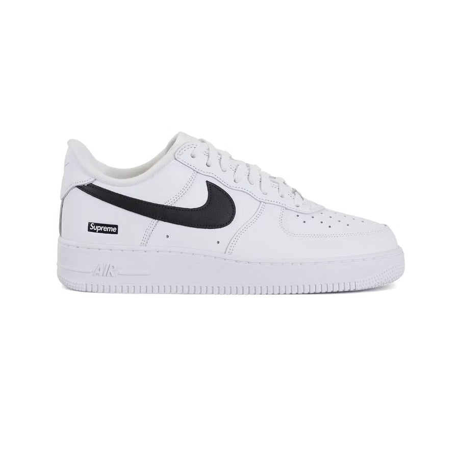 White NIKE Air Force 1 Low x Supreme sneaker with black Swoosh, Supreme box logo, and "AIR" on midsole.
