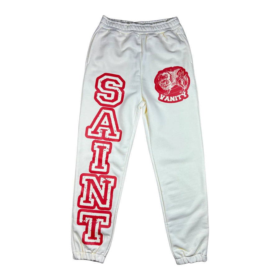 Cream Saint Vanity varsity sweatpants with "SAINT" in bold red on the left leg & a red lion logo with "VANITY" on the right hip.