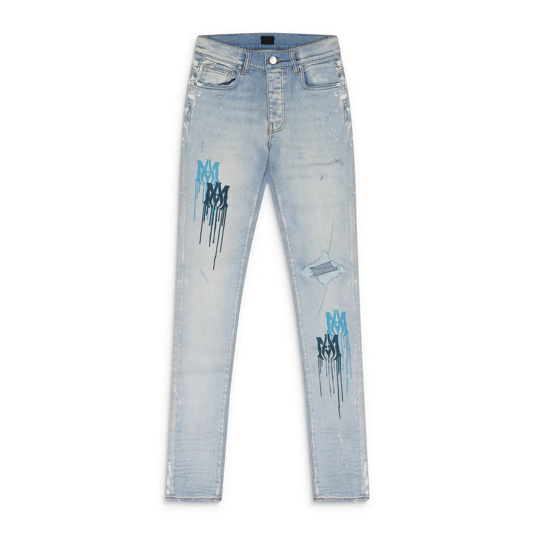 AMIRI light indigo jeans with a ripped knee, white paint splatters, and blue MA drip logos on both legs.