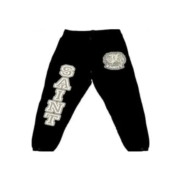 Black Saint Vanity Varsity Sweatpants with cream "SAINT" on left leg & circular "VANITY" emblem on right hip.
