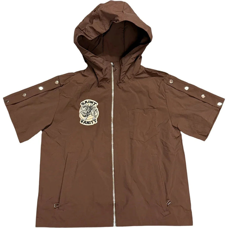 Brown nylon hooded short-sleeve top with "Saint Vanity" logo, silver front zip, snap buttons on sleeves, and zip pockets.