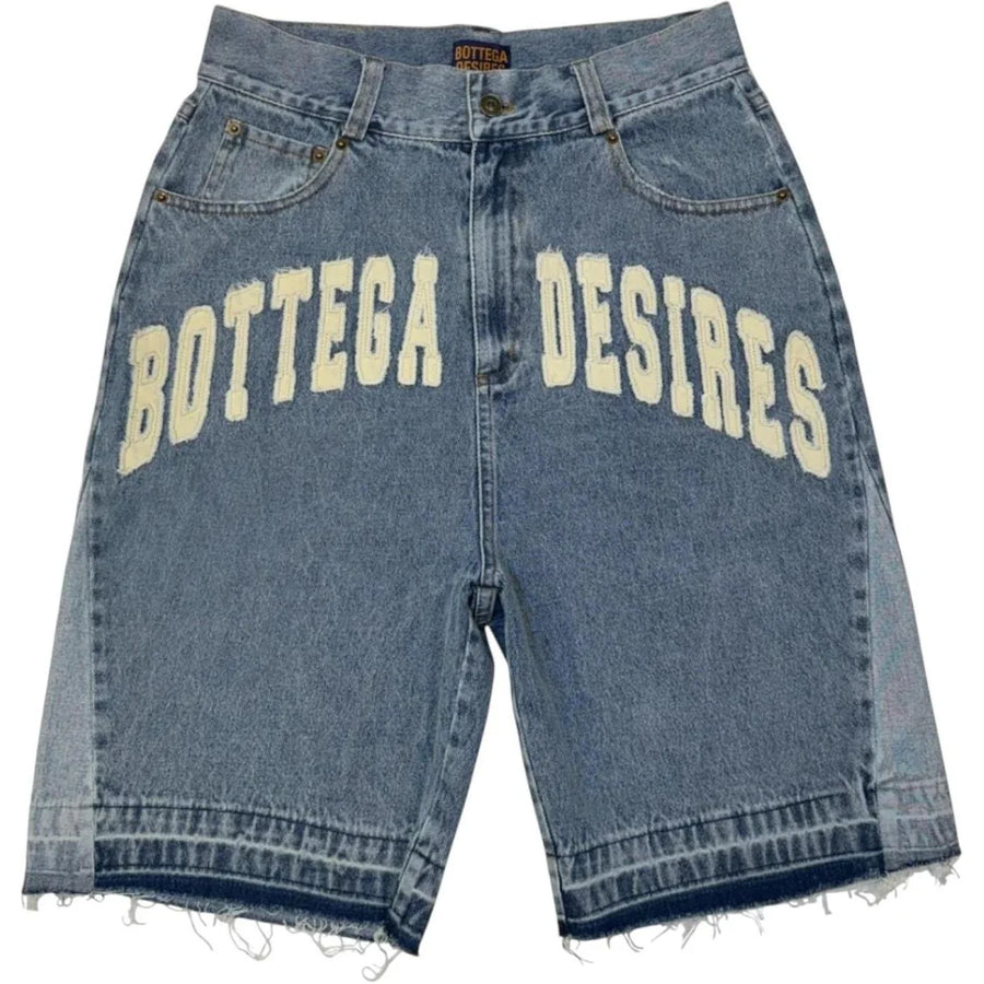 Bottega Desires light wash denim shorts with large cream 'Bottega Desires' text, faded side panels, and frayed hem.