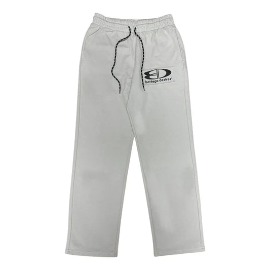 Grey Bottega Desires tech sweatpants with an elastic drawstring waist and black BD logo patch on the left thigh.