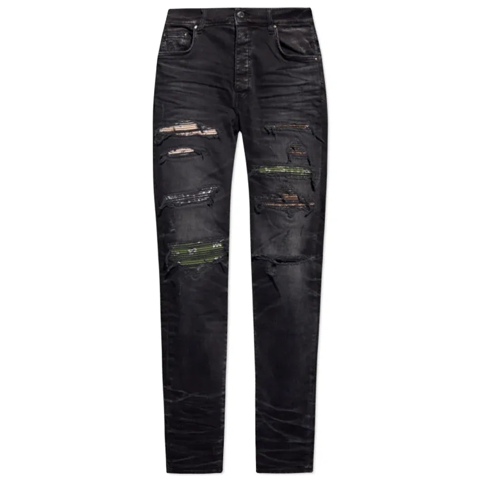 AMIRI Thrasher washed black distressed jeans with multiple rips revealing unique bandana camo patches.