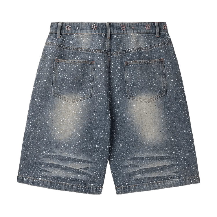 Washed blue "Iced Out Jorts" with all-over clear rhinestones, back pockets, and pink floral rhinestone clusters on the waistband.