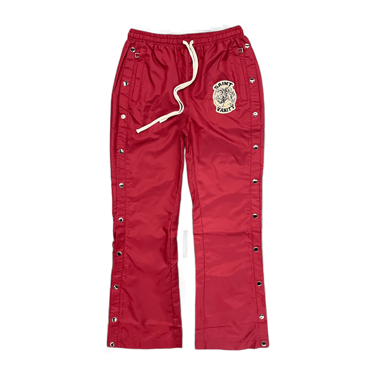 Maroon Saint Vanity nylon track pants with elastic waist, white drawstring, side snap buttons, and embroidered logo patch.