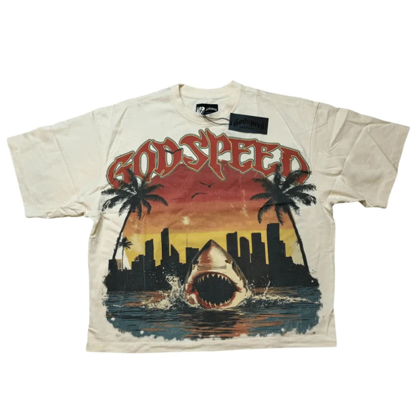 Cream Godspeed tee. Graphic: "GODSPEED" text over a shark breaching water, framed by palm trees & a Miami cityscape at sunset.