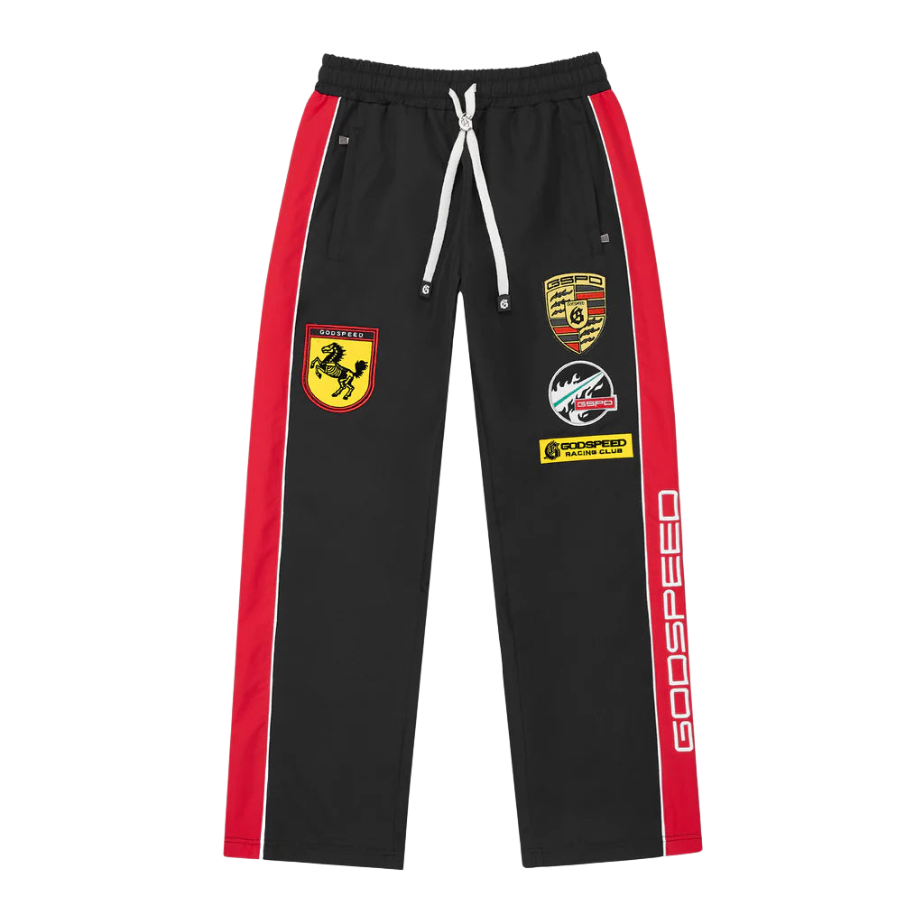 Black Godspeed GRC trackpants with red side stripes & white accents. Features multi-color racing patches on left leg and "GODSPEED" text on right leg.