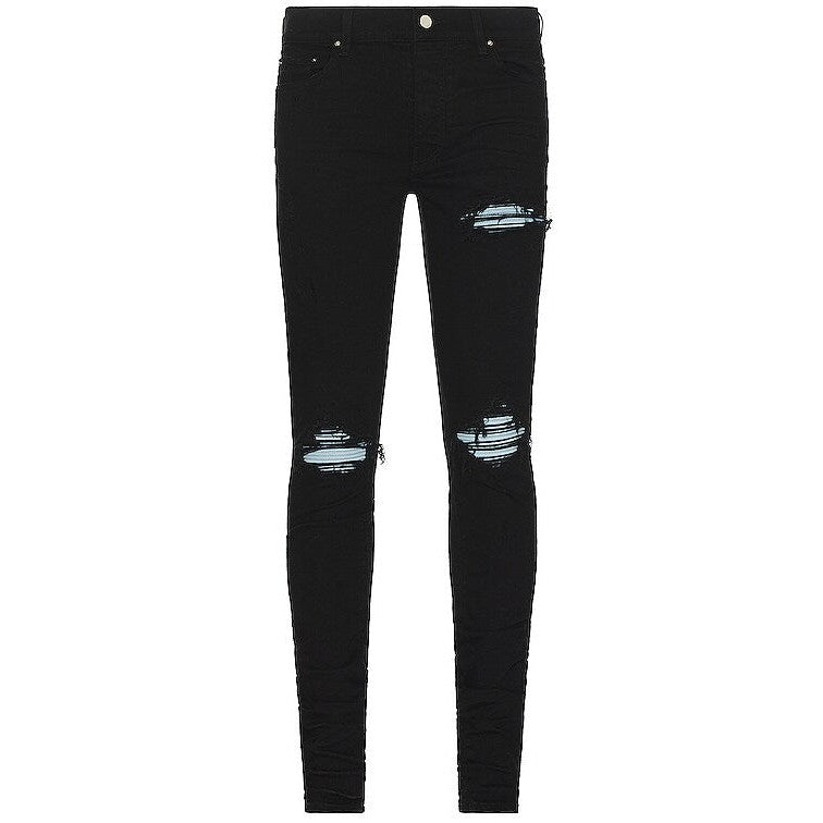 AMIRI OD Black Suede MX 1 skinny jeans with ripped knees and thigh, revealing light blue denim details.