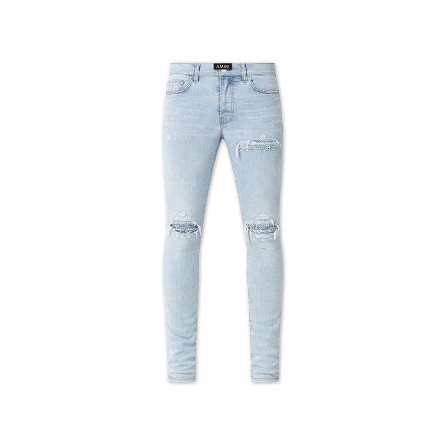 AMIRI Sky Indigo MX 1 jeans, light blue wash, with prominent rips at both knees and distressed details.