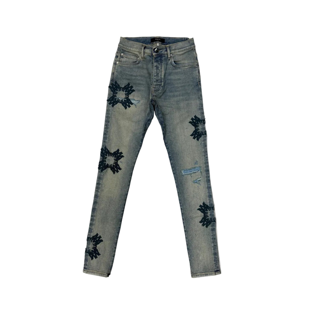 AMIRI Antique Indigo distressed jeans with dark, cross-like MA Quad appliques and button fly.